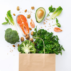 Shopping bag with healthy food on white background with copy space top view