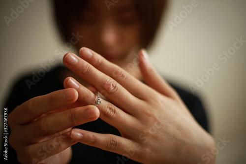 指輪を外す女性 © yamasan