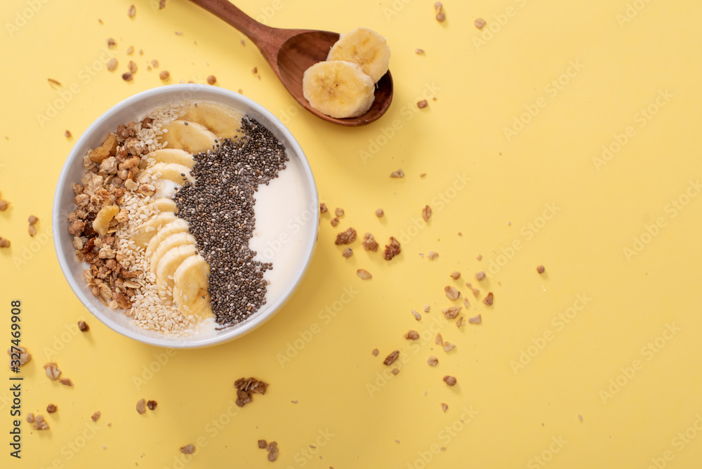 Healthy pineapple, mango smoothie bowl with coconut, bananas, blueberries and granola. Top view scene on a bright background.