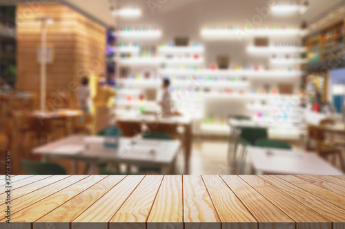 Blurred restaurant with modern design background and wood table top for graphic layout.