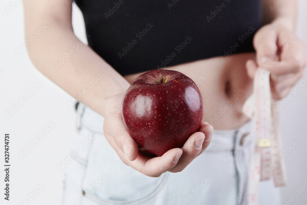 Εκτύπωση καμβά A woman with a red apple in one hand and a ruler in the other