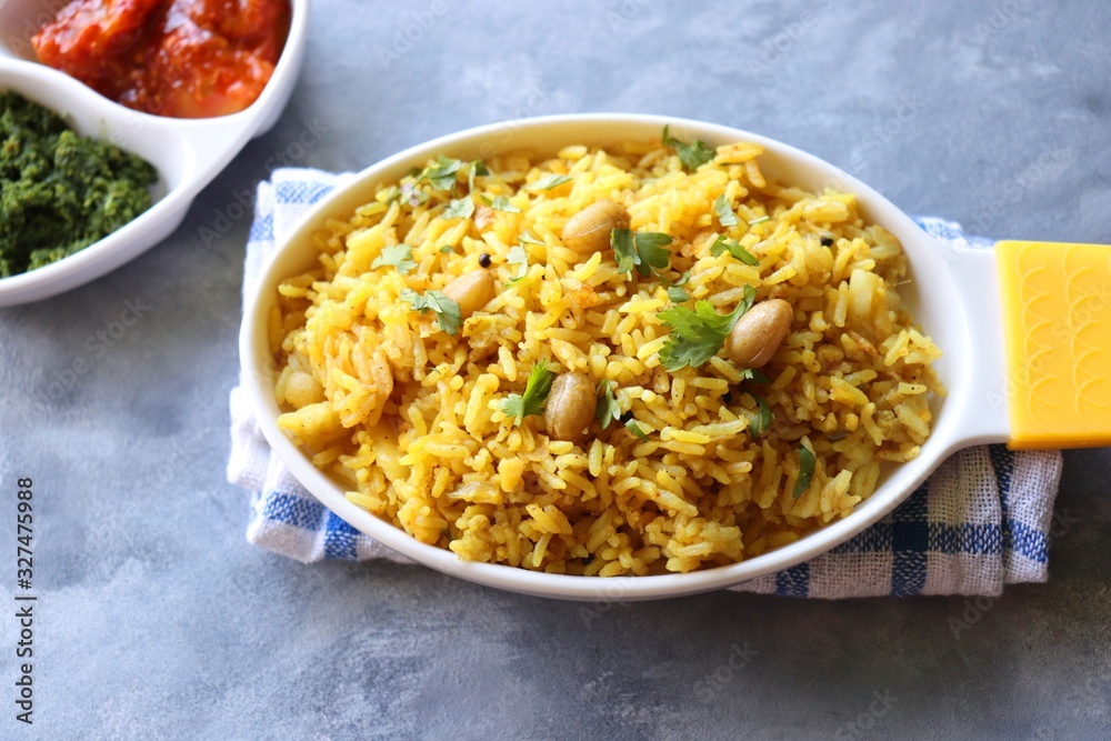 Indian comfort Food - Fresh Masala peanuts rice also known as Peanuts Pulav or rice khichdi. Garnished with coriander. Served hot with green chutney and mango pickle. with Copy space. Indian comfort Food - Fresh Masala peanuts rice also known as Peanuts Pulav or rice khichdi. Garnished with coriander. Served hot with green chutney and mango pickle. with Copy space.
