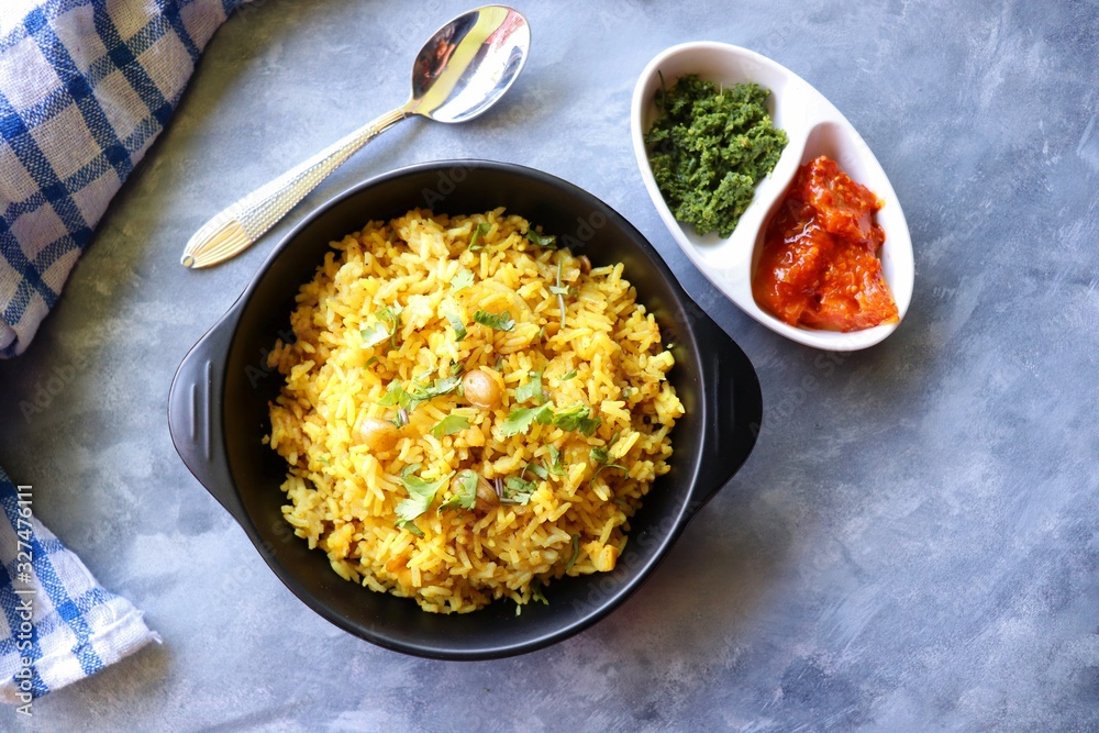 Indian comfort Food - Fresh Masala peanuts rice also known as Peanuts Pulav or rice khichdi. Garnished with coriander. Served hot with green chutney and mango pickle. with Copy space. Indian comfort Food - Fresh Masala peanuts rice also known as Peanuts Pulav or rice khichdi. Garnished with coriander. Served hot with green chutney and mango pickle. with Copy space.