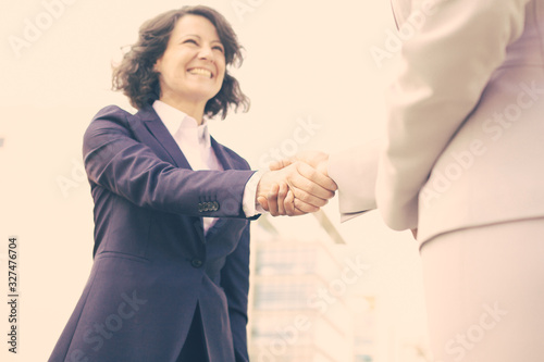 Bottom view of business handshake. Cropped shot of two people wearing formal suits shaking hands. Business handshake concept © Mangostar