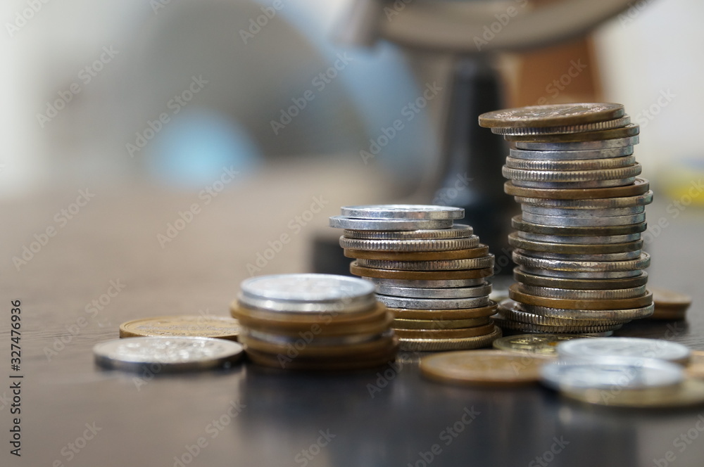 we have try keep collecting more money in order to travel and make a great journey for all around the world. many coins counted on the table with globe background for financial concept we have try keep collecting more money in order to travel and make a great journey for all around the world. many coins counted on the table with globe background for financial concept