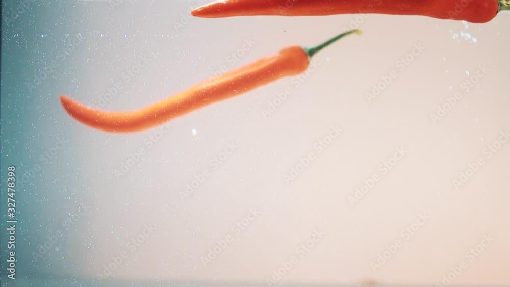 red chili pepper falls into the water close-up red chili pepper falls into the water close-up