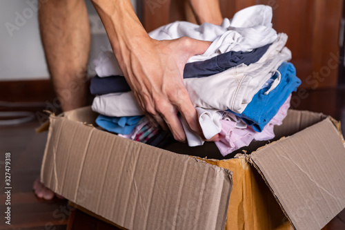 Putting clothes into a cardboard box for donation