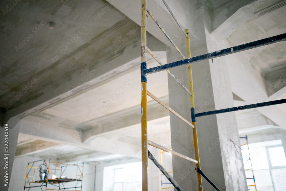 Obraz premium Interior construction of warehouse concrete wall and scaffolding.