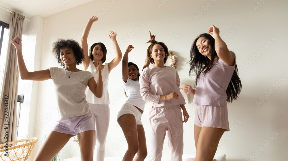 Fototapeta premium Portrait beautiful diverse girls dancing on bed together