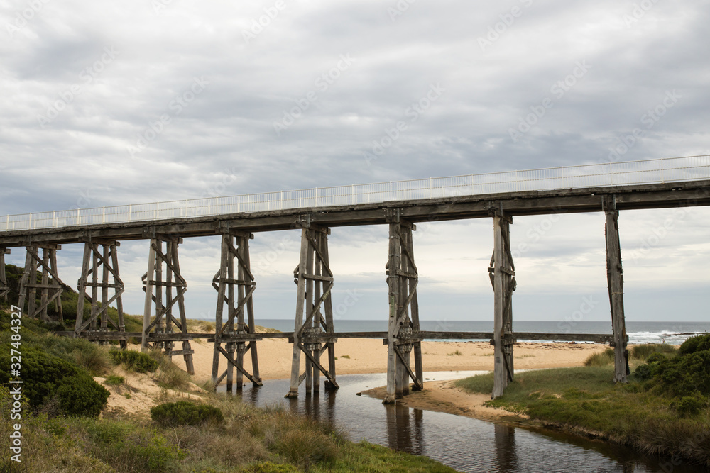 Gipplsand, Kilcunda Bourne Creek Trestle bridge on an overcast day with ocean in background.