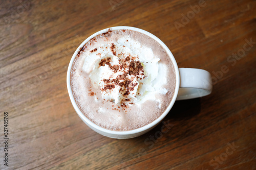 Take a break with hot chocolate cocoa with whipped cream on wooden table in the morning