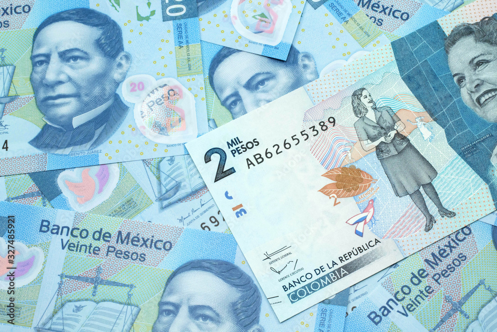 Naklejka premium A close up image of a blue two thousand Colombian peso bank note on a background of Mexican twenty peso bank notes in macro