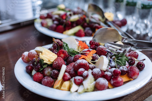 Plate with fruits and berries on servered buffet table at luxury wedding reception outdoors. Catering banquet table in restaurant. Restaurant presentation  food  party concept.