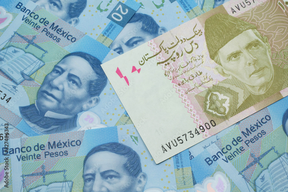 Fototapeta premium A close up image of a gray and pink twenty Pakistani rupee bank note with Mexican twenty peso bank notes in macro