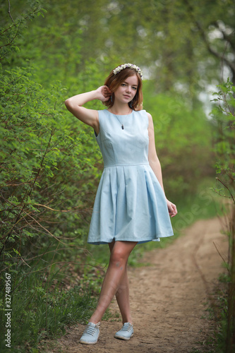 Girl in blue dress in green park
