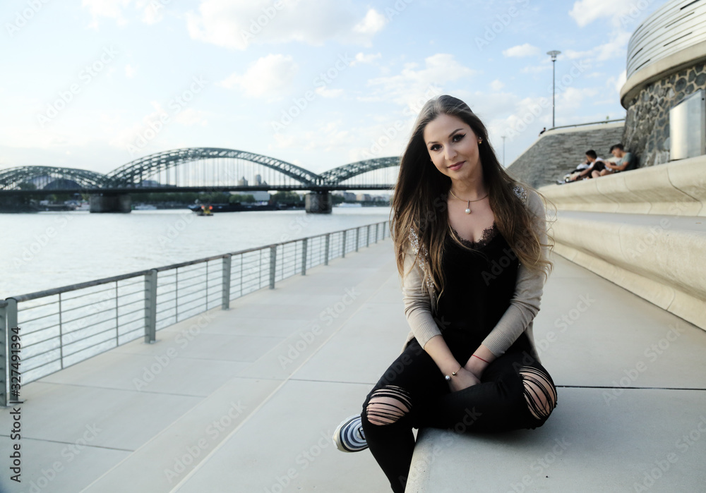 Fototapeta premium Beautiful stylish woman sitting on street stairs on summer day