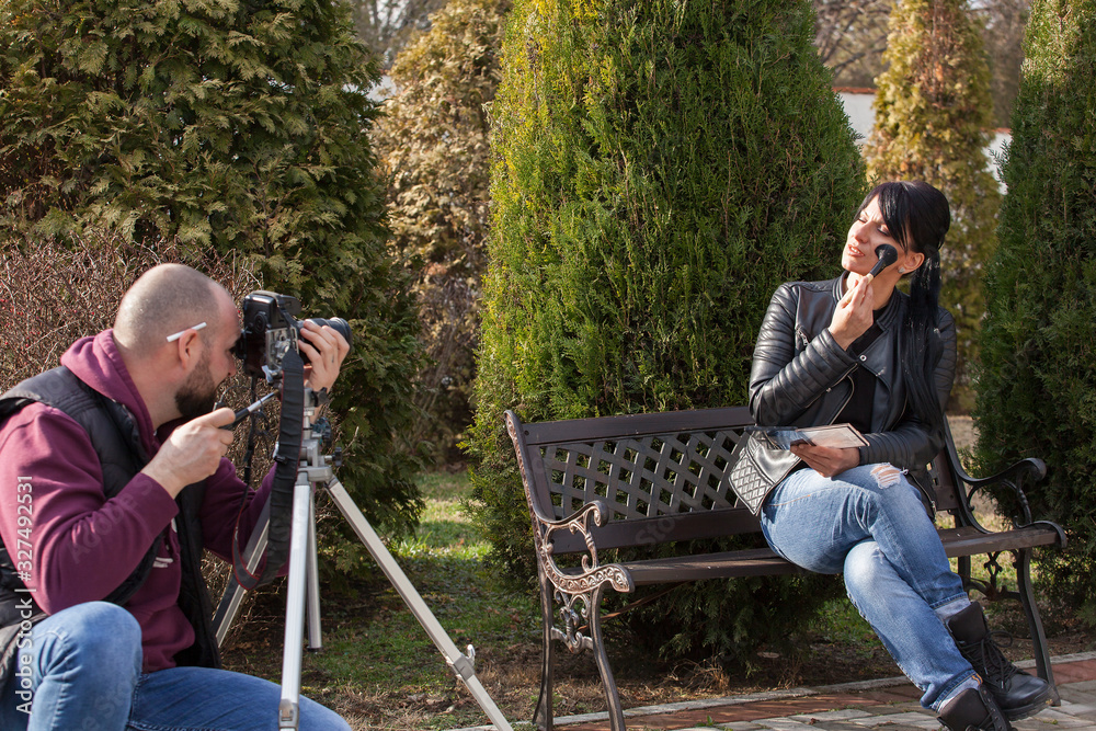 beautiful girl photomodel in black leather jacket, sitting on a bench and posing and makeup, photographer taking pictures beautiful girl photomodel in black leather jacket, sitting on a bench and posing and makeup, photographer taking pictures