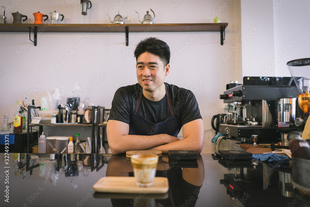 Cheerful success Asian barista! - The coffee shop startup owner stitting at the coffee counter Cheerful success Asian barista! - The coffee shop startup owner stitting at the coffee counter