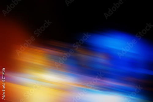 Abstract blurred color blurred dark background, orange, cyan, black and light spots.