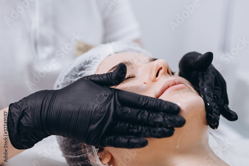 Female beautician doctor with patient in wellness center. Professional cosmetologist make procedure to beautiful girl in cosmetology cabinet or beauty parlor