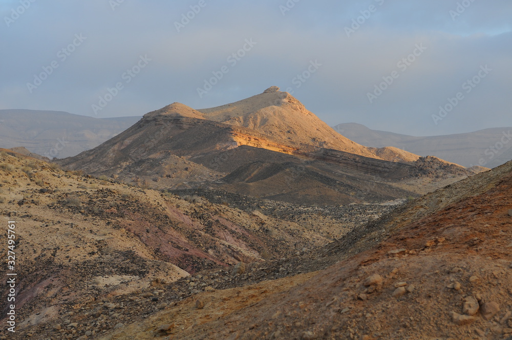 Desert landscape at sunrise. Hiking desert part of Israel National Trail. Negev desert . Valley. Colorful sands Desert landscape at sunrise. Hiking desert part of Israel National Trail. Negev desert . Valley. Colorful sands