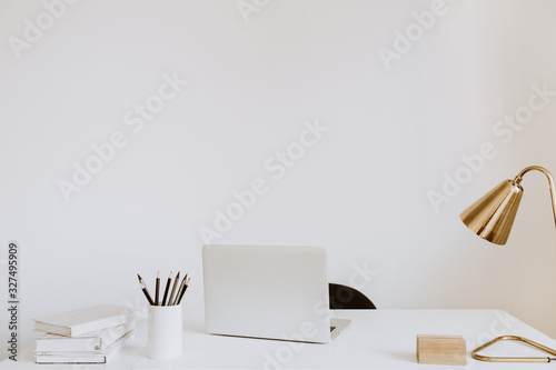 Plakat Modern minimal interior design concept. Home office desk table workspace with laptop, lamp, books. Women's business work concept.