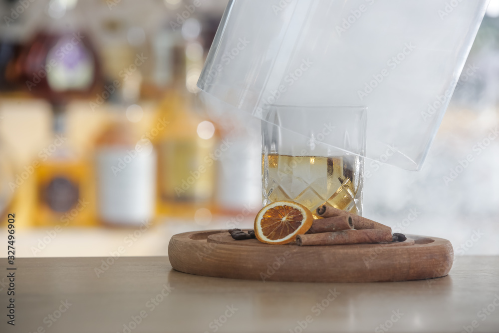 Hazy Whiskey Cocktail, A glass of smoked whiskey served with a slice of dry orange and cinamon stick Hazy Whiskey Cocktail, A glass of smoked whiskey served with a slice of dry orange and cinamon stick