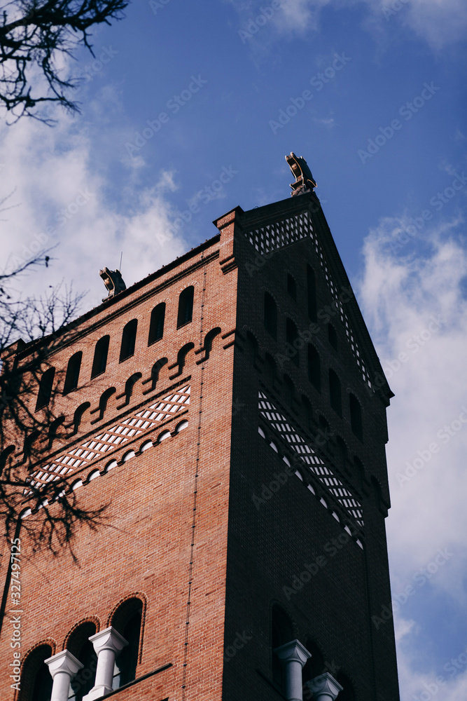 Fototapeta premium Red Catholic Church against the blue sky in Minsk