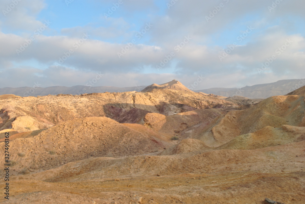 Desert landscape at sunrise. Hiking desert part of Israel National Trail. Negev desert . Valley. Colorful sands Desert landscape at sunrise. Hiking desert part of Israel National Trail. Negev desert . Valley. Colorful sands
