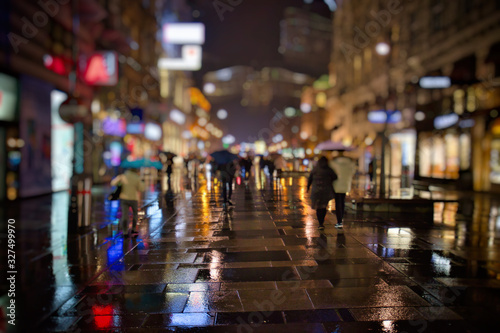 Crowd of anonymous people walking on night city street