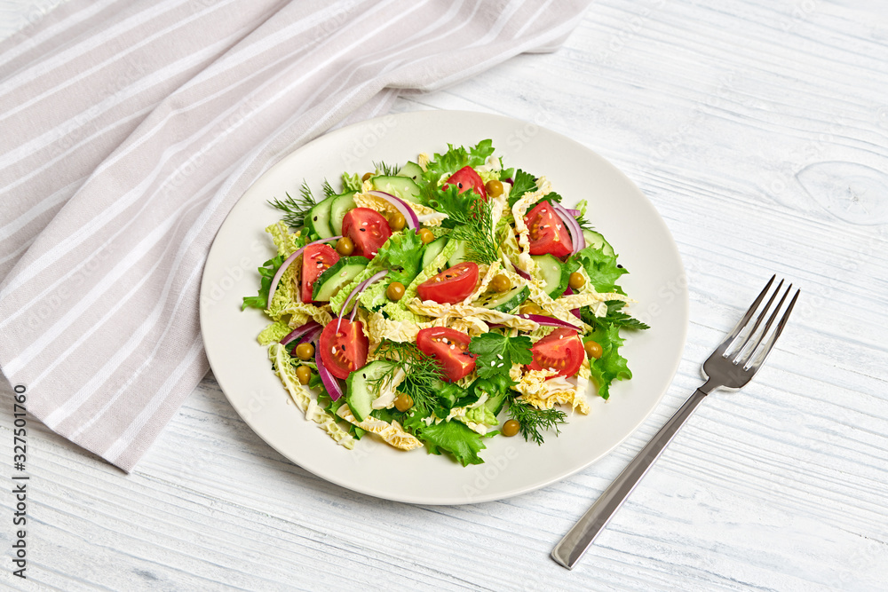 Fresh salad with cherry tomatoes, savoy cabbage, cucumeber on dish. Healthy summer salad vegetarian meal concept. Tasty mixed leaves, tomatoes and mix vegetable salad on white wood Fresh salad with cherry tomatoes, savoy cabbage, cucumeber on dish. Healthy summer salad vegetarian meal concept. Tasty mixed leaves, tomatoes and mix vegetable salad on white wood