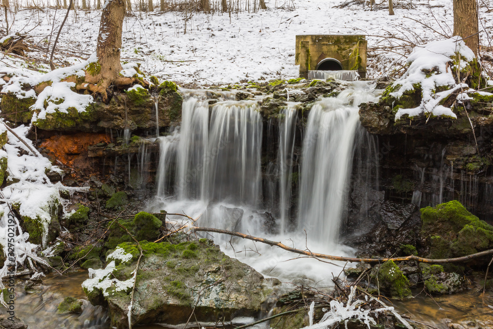 City Sigulda, Latvia. Waterfall in winter. White snow and trees. Travel photo.
