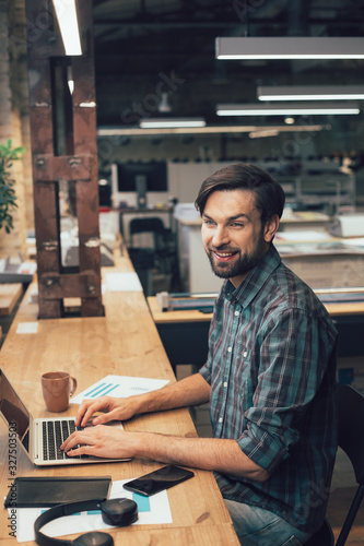 Gladsome man typing on laptop keyboard stock photo