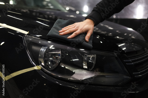 Car care concept. Detailing master polishes a car