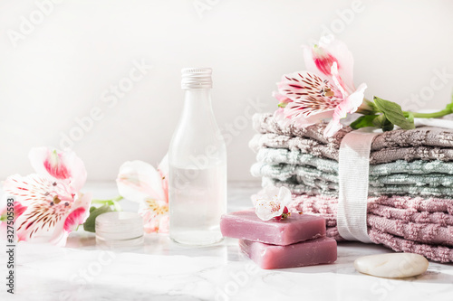 natural soap. handmade soap with a bottle of oil. Stack of fresh towels with flowers on a white background. spa treatments.