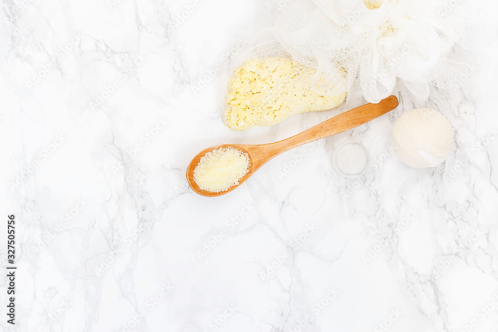 sea salt in a wooden spoon, washcloth, pumice for feet on a white background. yellow bathing salt in the wooden spoon, spa concept sea salt in a wooden spoon, washcloth, pumice for feet on a white background. yellow bathing salt in the wooden spoon, spa concept