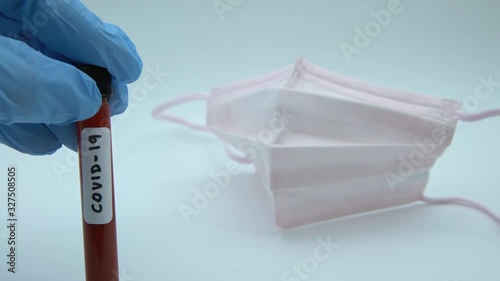 4K, Protective raspiratory mask and surgical gloves with a positive coronavirus infected blood sample test. Hand of scientist doctor biohazard protection clothing-Dan photo