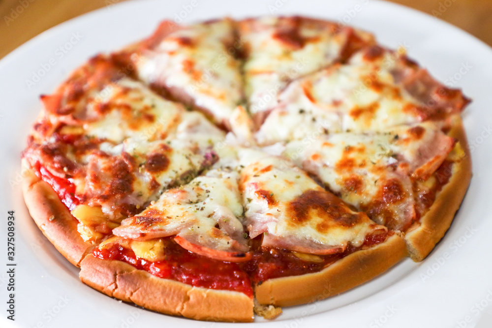pizza with ham and tomato on plate