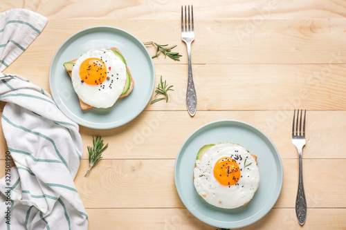 Plates with fried eggs on wooden background