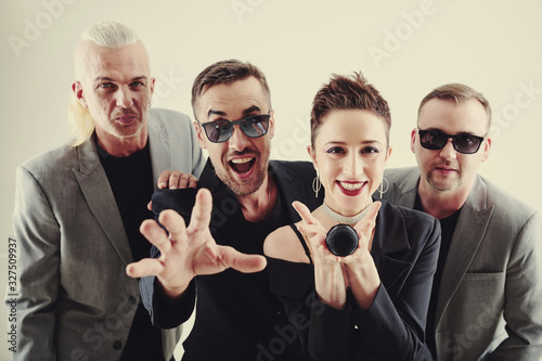 Cheerful excited musicians offering you microphone and asking to sing at karaoke photo