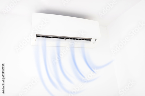 Modern air condition unit on a white wall inside the living room. photo