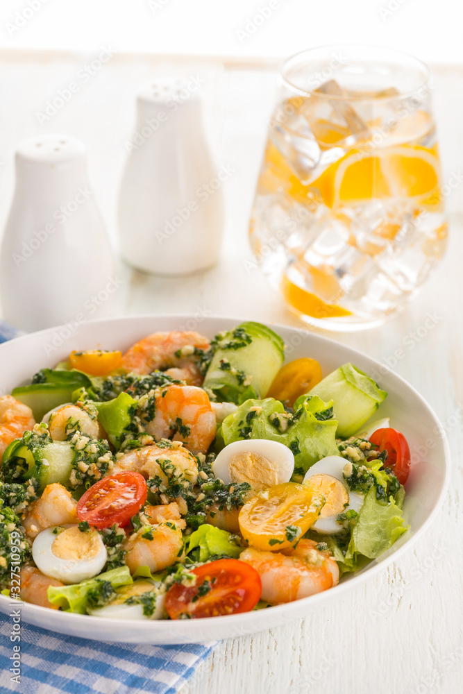 Salad with grilled shrimps, fresh lettuce, cucumbers, cherry tomatoes and quail eggs with pesto sauce. Salad with grilled shrimps, fresh lettuce, cucumbers, cherry tomatoes and quail eggs with pesto sauce.