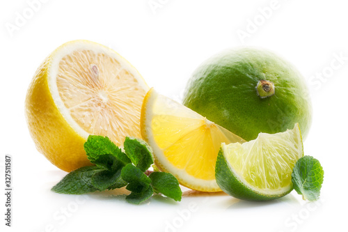 Fresh and juicy lime and lemon cut into pieces, with green leaves and mint