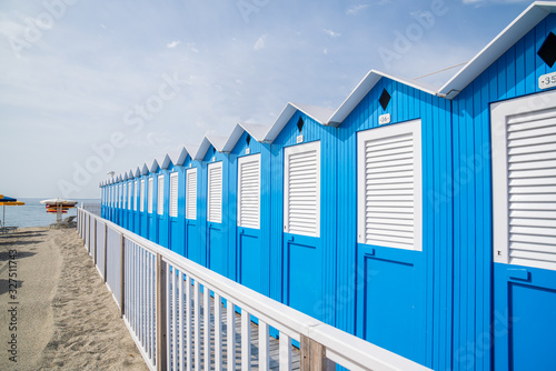 Fototapeta Naklejka Na Ścianę i Meble -  Traditional Italian beach huts on a bright sunny day,Blue beach cabins arranged in rows up on the seashore,Varazze Liguria Italy.