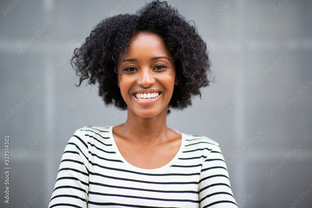 Fototapeta premium Close up beautiful young african american woman smiling by gray wall