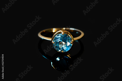 Beautiful old golden ring with blue gemstone isolated on white background