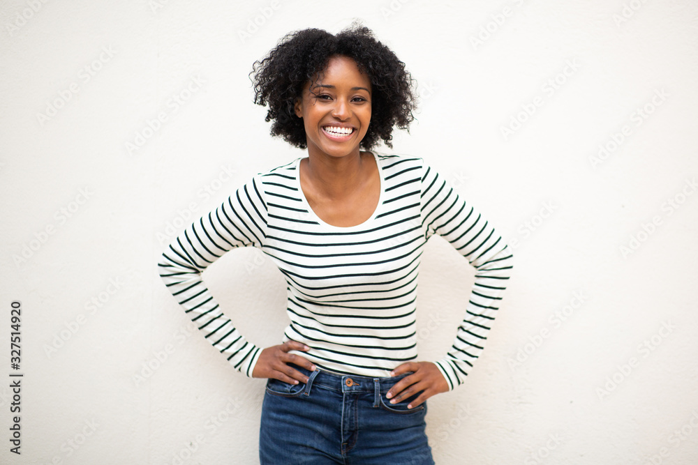 smiling young beautiful black woman with hands on hip against white ...