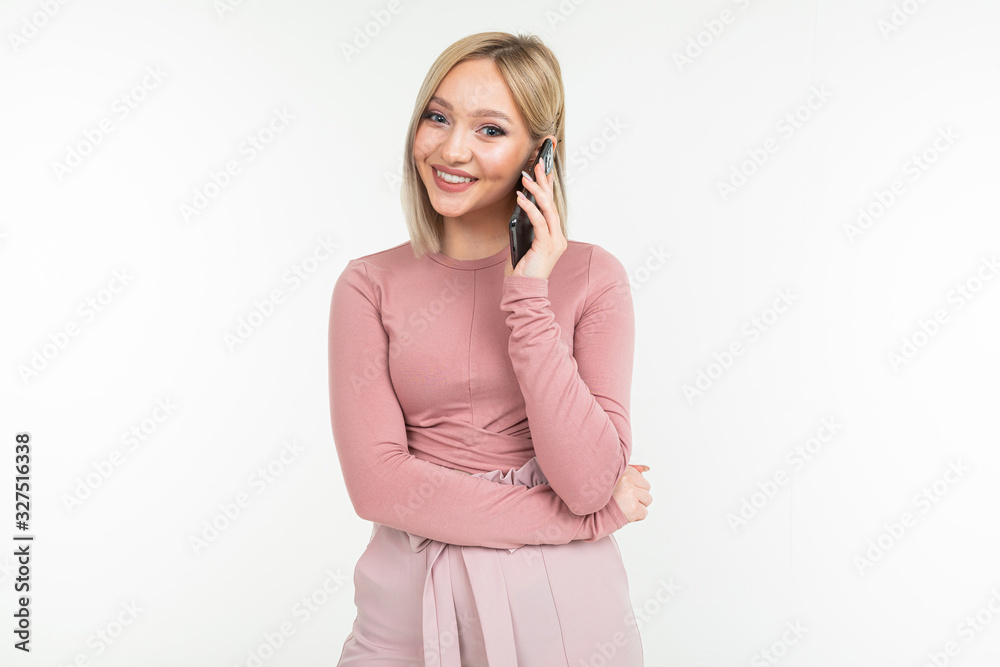 lovely blond girl in pink clothes chatting on the phone on a white background lovely blond girl in pink clothes chatting on the phone on a white background