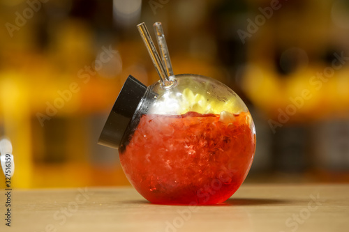 Schilderij op canvas A glass of beautifully decorated red fishbowl cocktail
