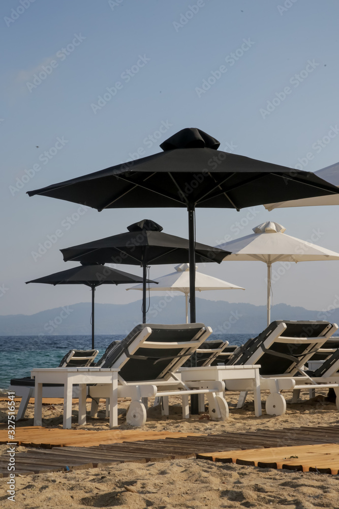 Luxurious sunbeds and umbrellas on a sandy beach Luxurious sunbeds and umbrellas on a sandy beach